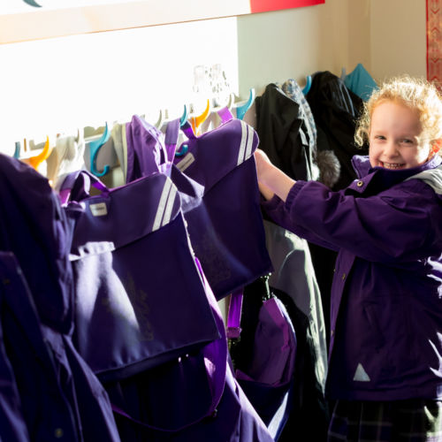 wycliffe nursery girl smiling and wearing a trenchcoat