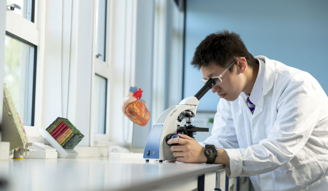 wycliffe pupil using a microscope in a lab