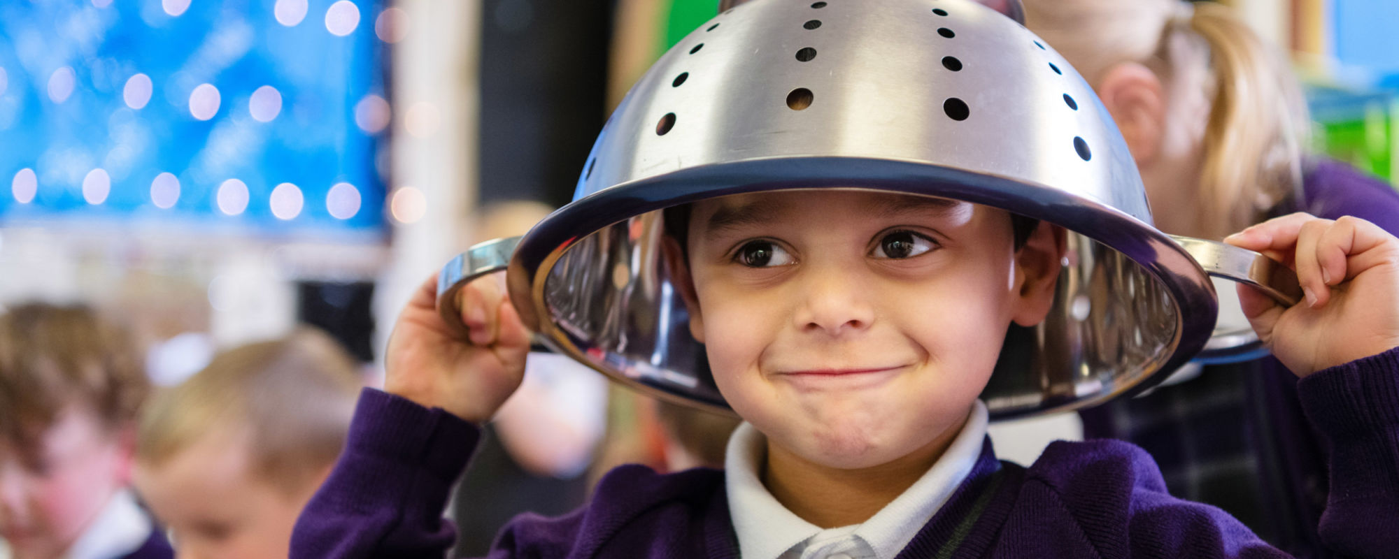 wycliffe nursery pupil putting a strainer on his head