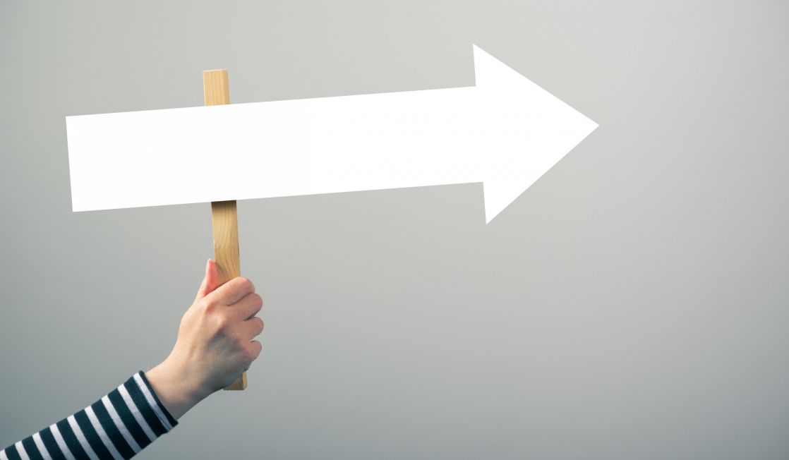 woman holding directional signage