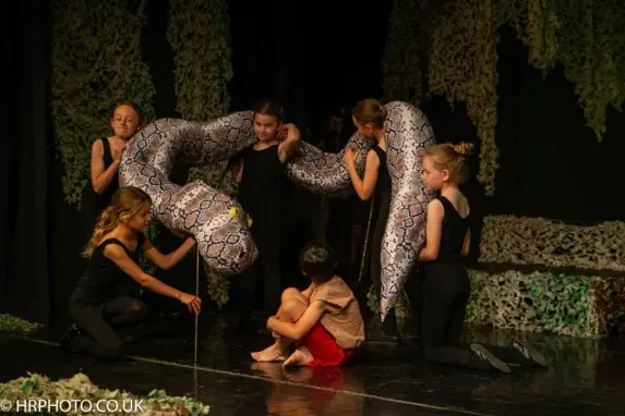 wycliffe pupils using a prop snake on a stage