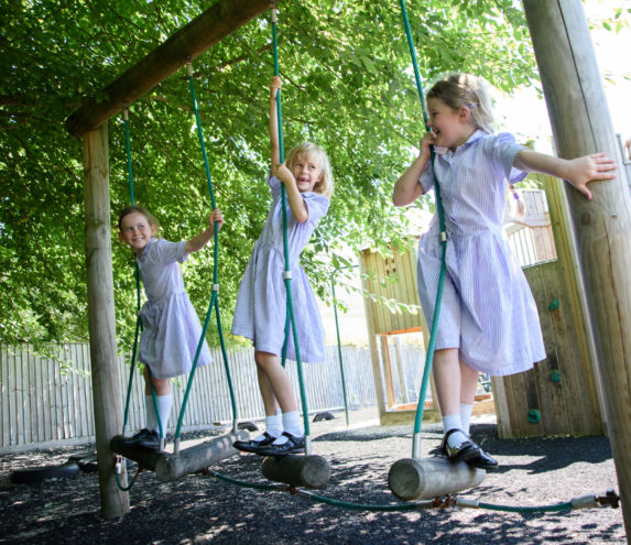 trio of wycliffe girls playing on swings