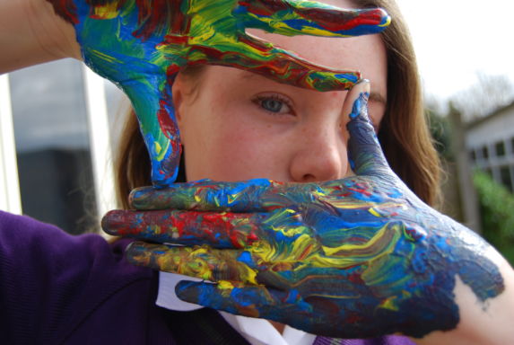 wycliffe girl holding her painted hands in a rectangle