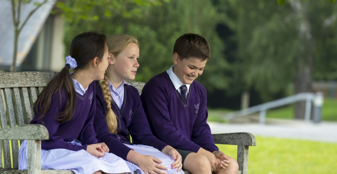 wycliffe pupils sitting on a bench outside