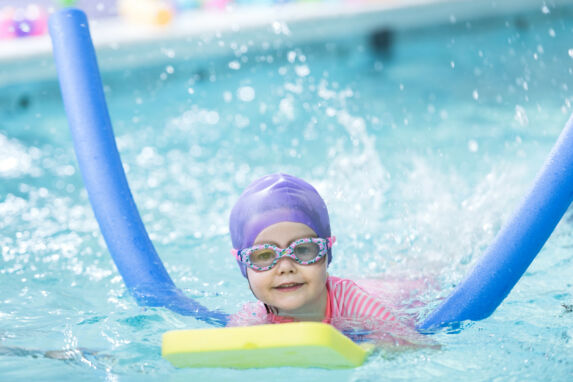 wycliffe girl swimming with a board