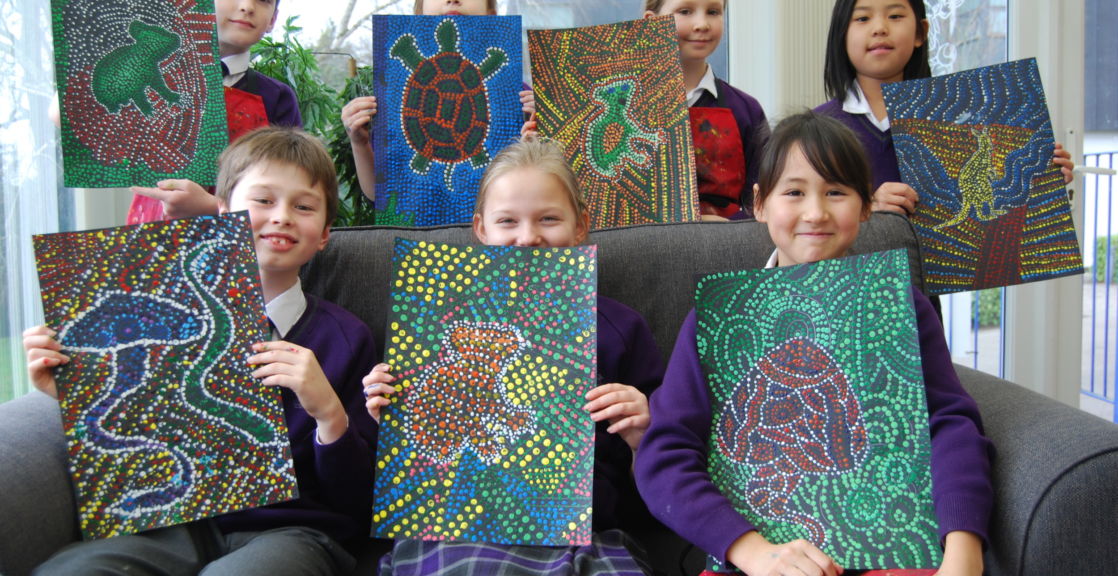 group of wycliffe students holding their paintings