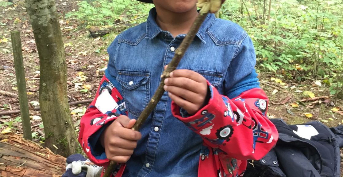 wycliffe boy in the woods holding a stick