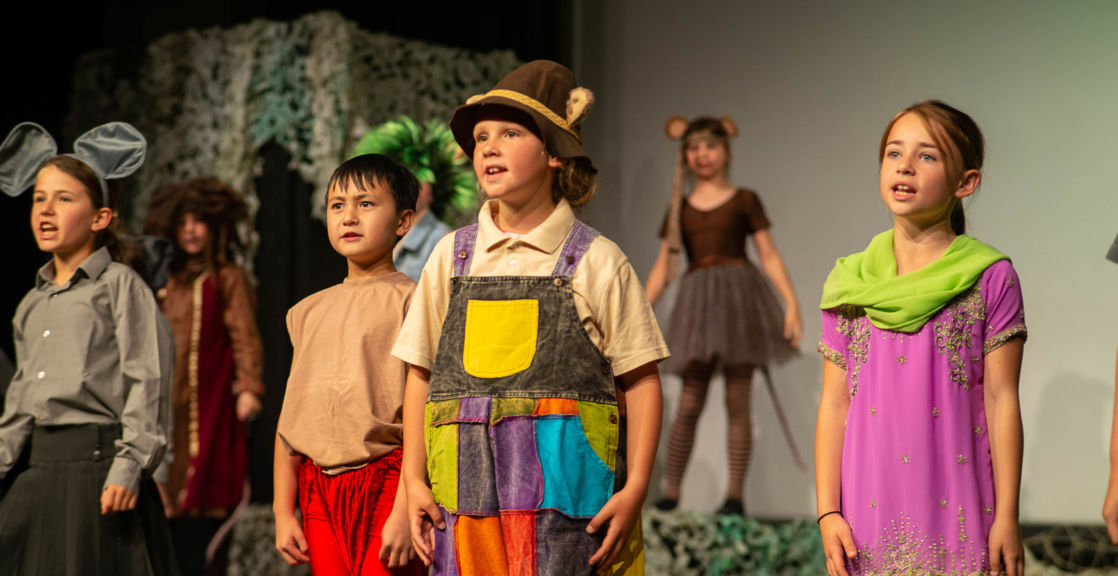 wycliffe kids wearing costumes on stage