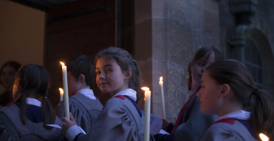 wycliffe pupils walking into a chapel holding candles