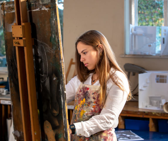 Wycliffe College student painting a piece of art