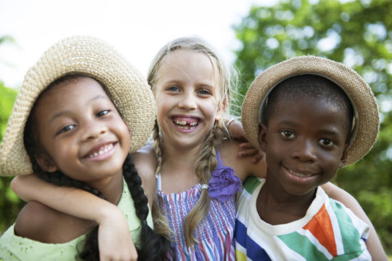 Boy with two girls having fun outside posing for picture