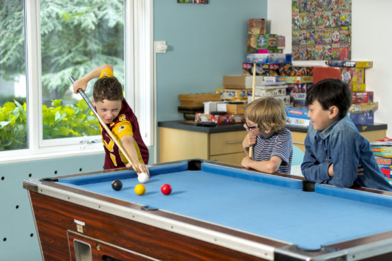 Prep boys playing pool in their boarding house