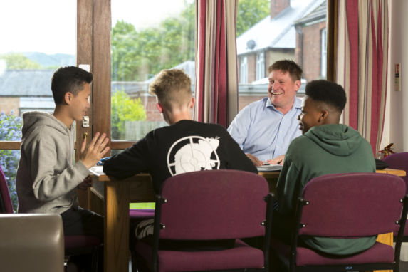wycliffe boys and teacher talking at the table